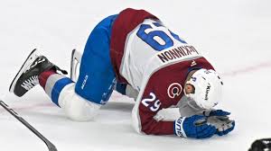 MacKinnon hit in face by teammate's puck, returns to play